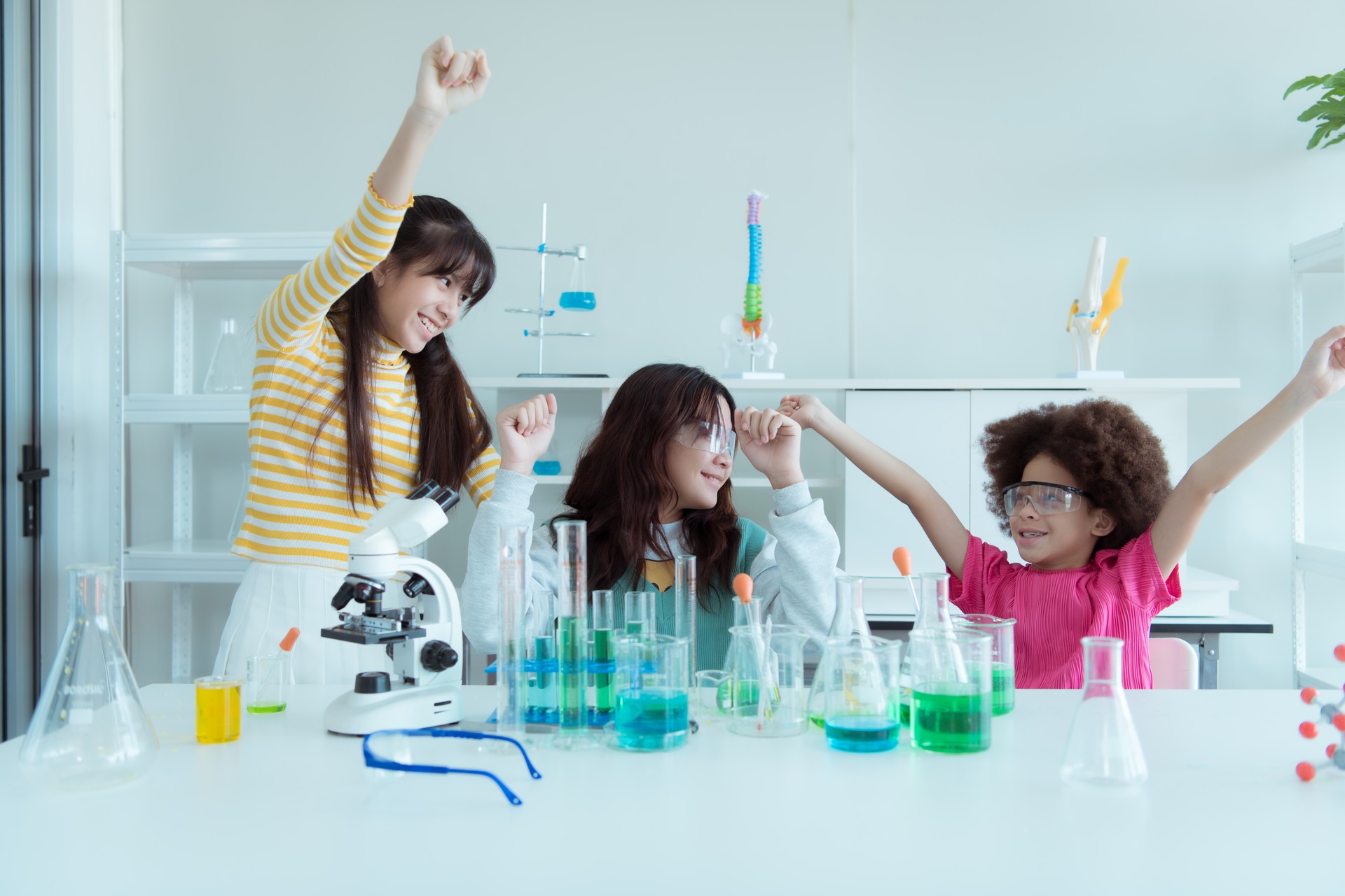 In the science classroom, an Asian child scientist experimenting with scientific formulas with chemicals