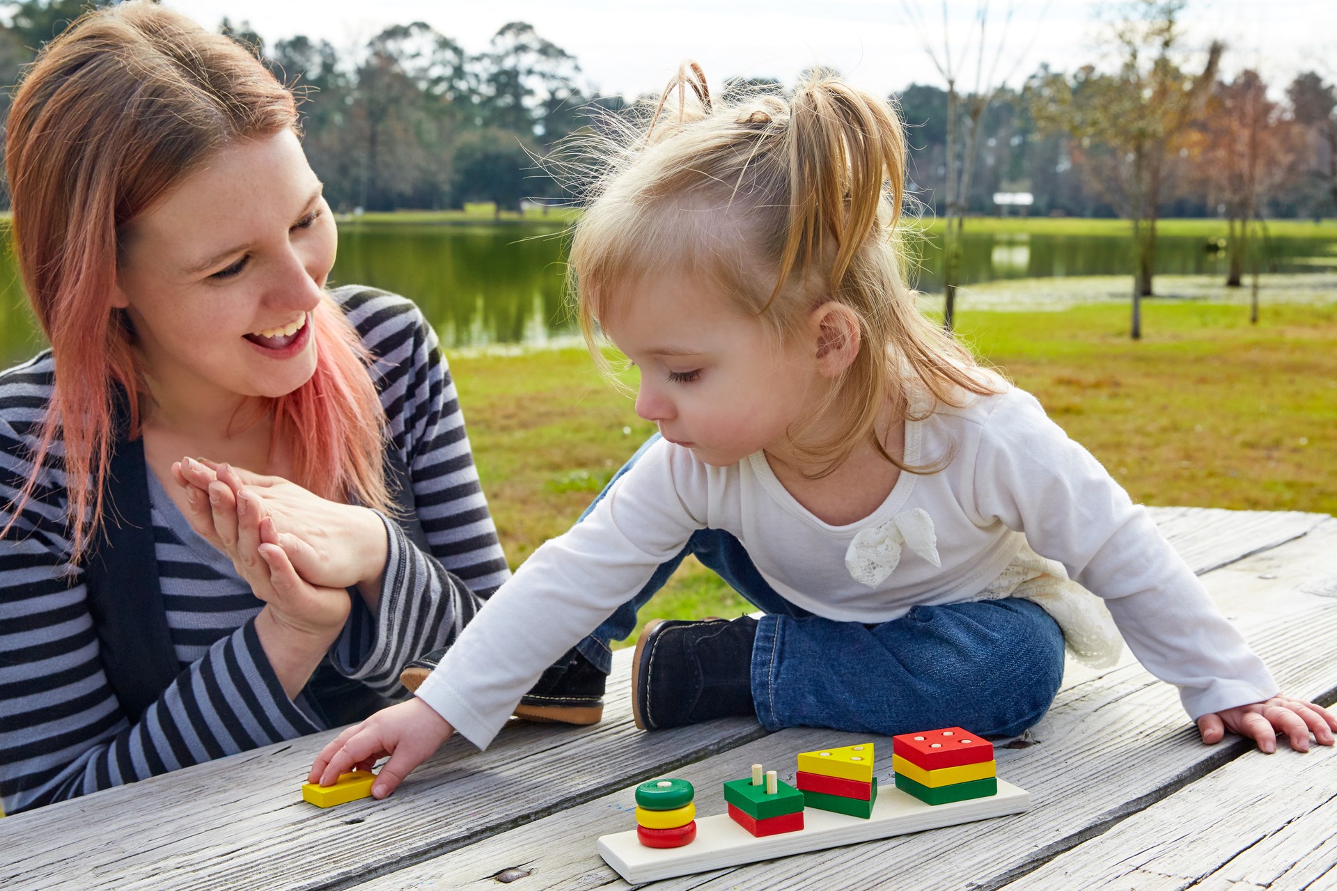 Mother and daughter playing with shapes in park