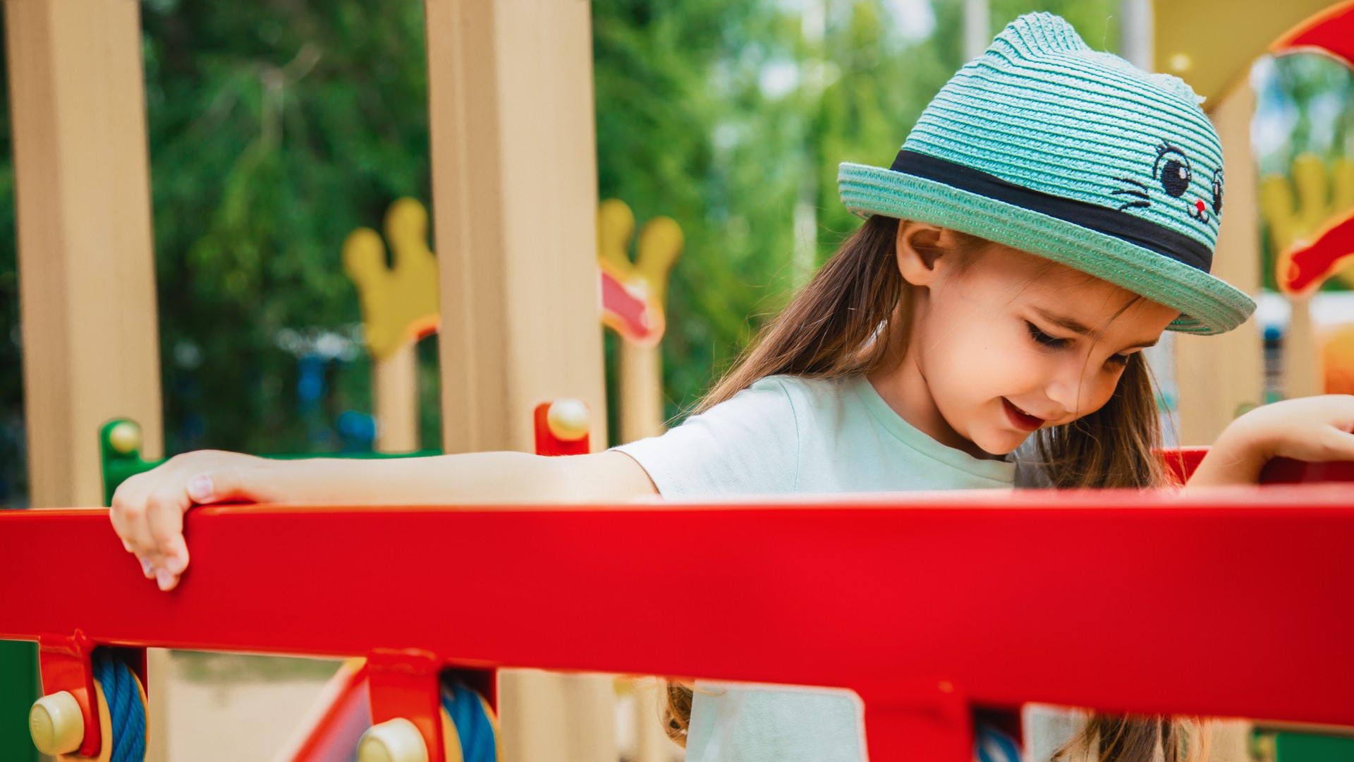 Child girl playing at the playground in summer day